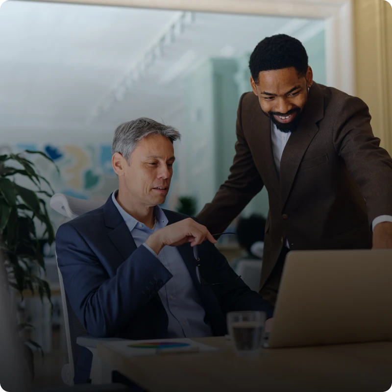 Two men collaborating on a laptop.